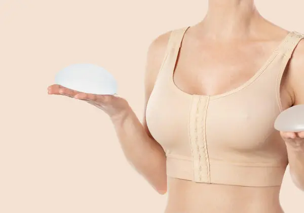 Women holding breast implants