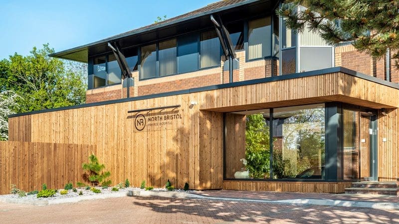The beautiful timber exterior of North Bristol Private Hospital, lit by spring sunshine.