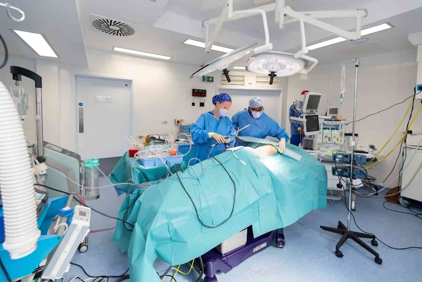 Ms Elena Prousskaia in the operating theatre with another surgeon performing surgery.
